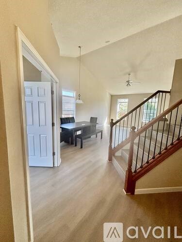 A hallway with a staircase and a table with chairs.