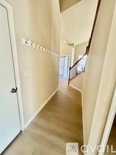 A hallway with a white door and a white wall.