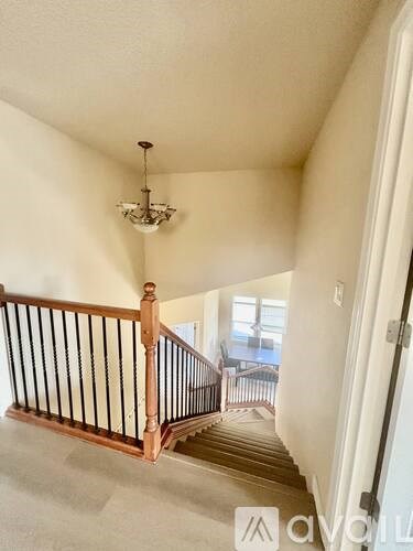 A staircase with a chandelier hanging from the ceiling.