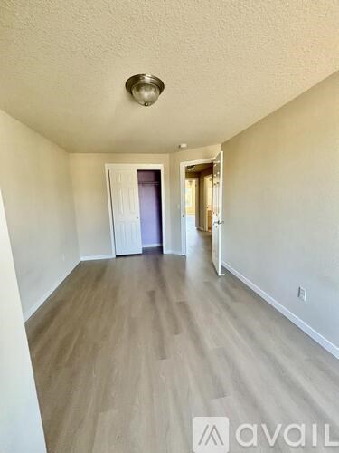 A long hallway with wood floors and white walls.