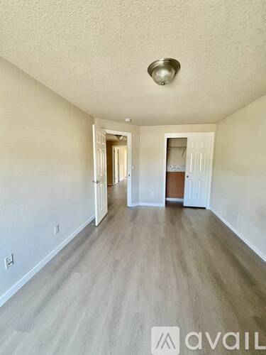 A long hallway with wood floors and white walls.