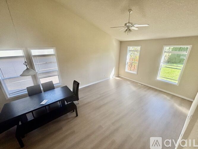 A room with a table and chairs and a ceiling fan.
