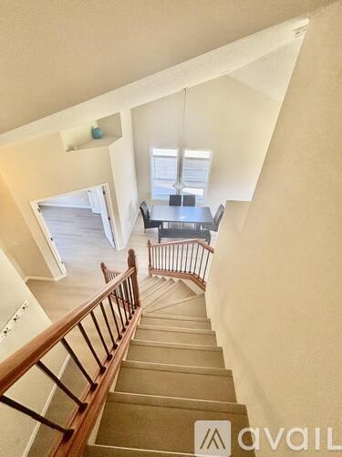 A staircase with a railing leading to a living room.