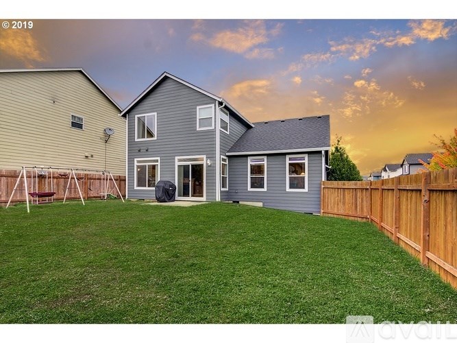 A house with a grey exterior and a wooden fence in front of it.