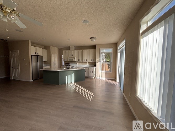 A spacious kitchen with a fan and a dining table.