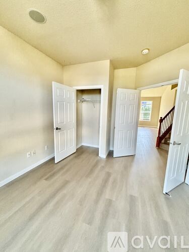 A room with white doors and a wooden floor.