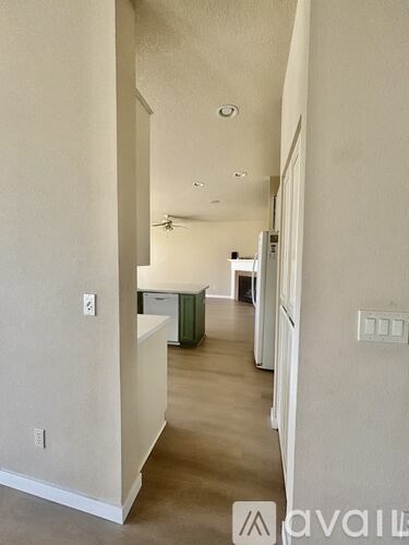 A long hallway with a kitchen area at the end.