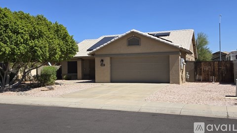 A house with a garage and a driveway in front of it.