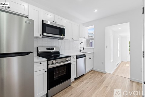 A kitchen with white cabinets and stainless steel appliances.