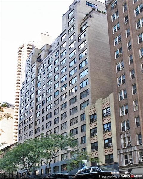 a tall building with cars parked in front of it
