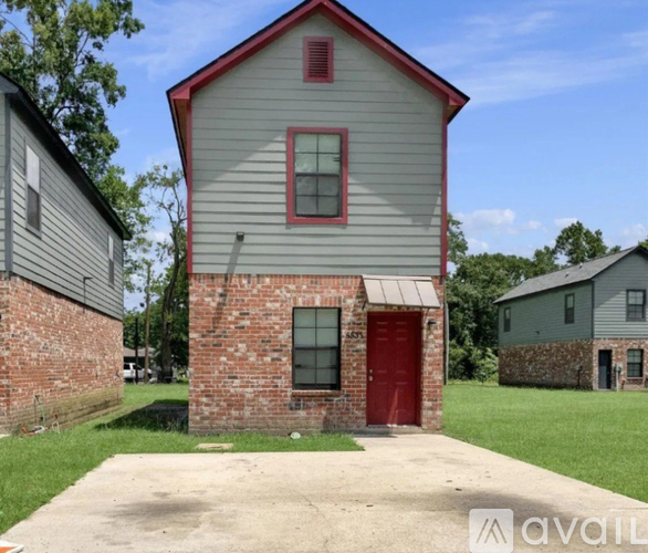 A house with a red door and a red window is for sale.