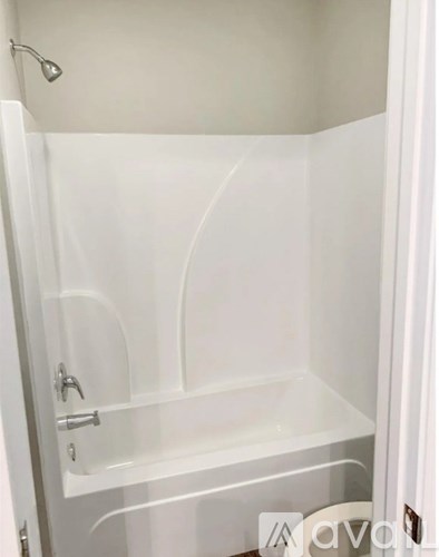 A white bathroom with a shower stall and a toilet.