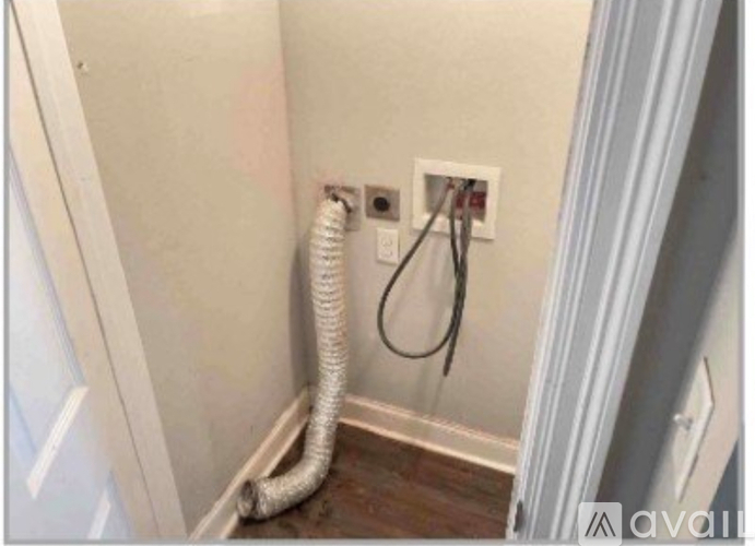 A white wall socket with a white extension cord plugged into it.