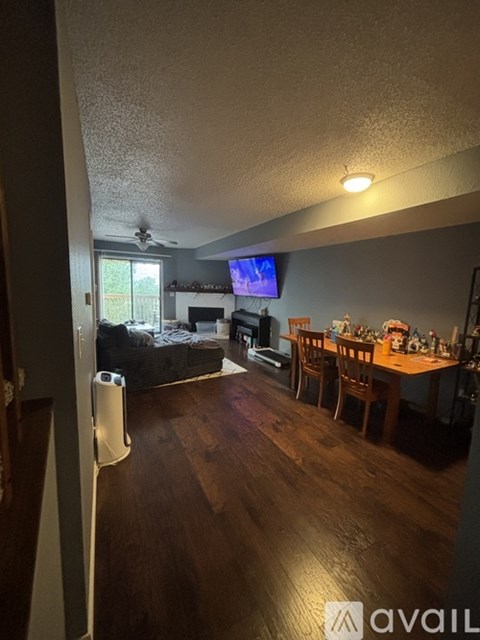 A living room with a television and a dining table.