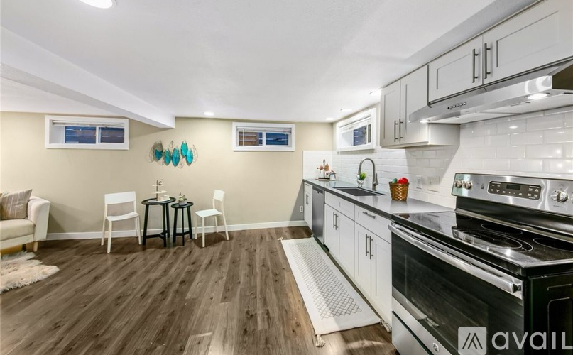 A kitchen with a black stove top oven and white cabinets.