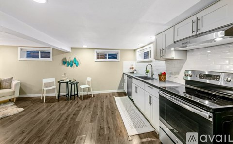 A kitchen with a black stove top oven and white cabinets.