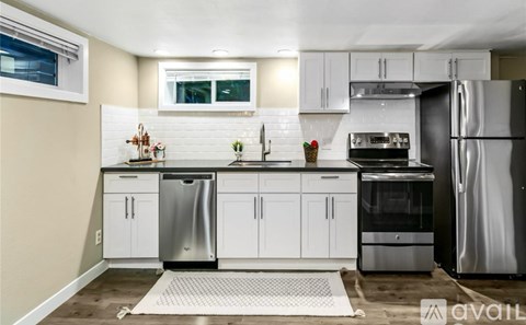 A kitchen with white cabinets and stainless steel appliances.