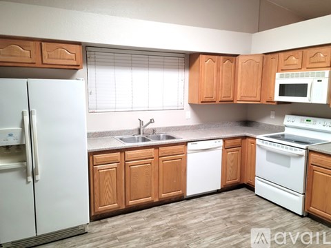 A kitchen with wooden cabinets and white appliances.