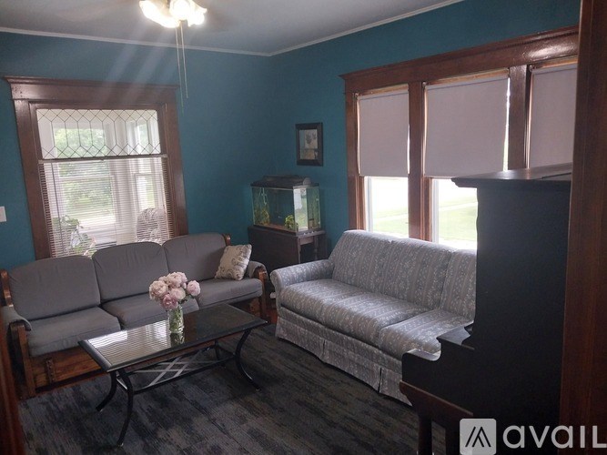A living room with a grey sofa and a glass table.