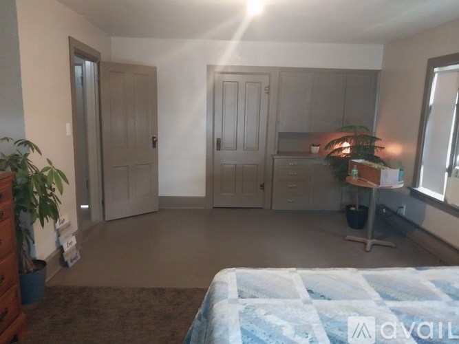 A bedroom with a bed, dresser, and a window.