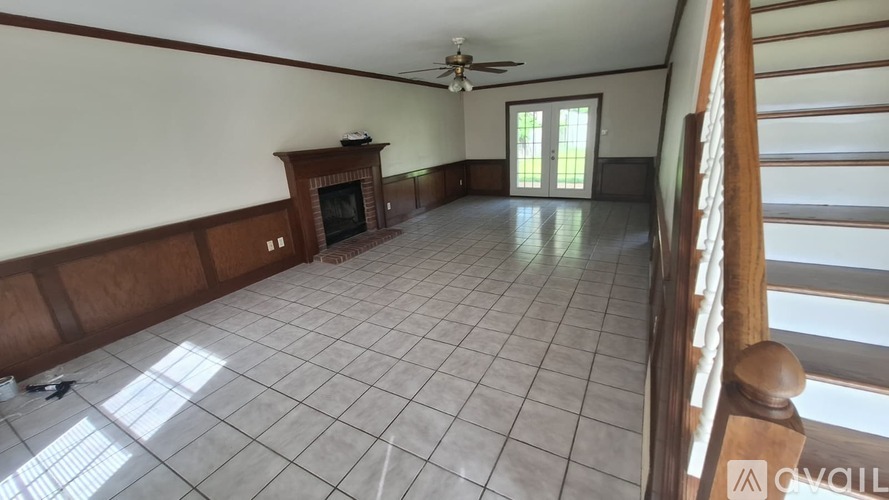 A spacious room with a fireplace and a ceiling fan.