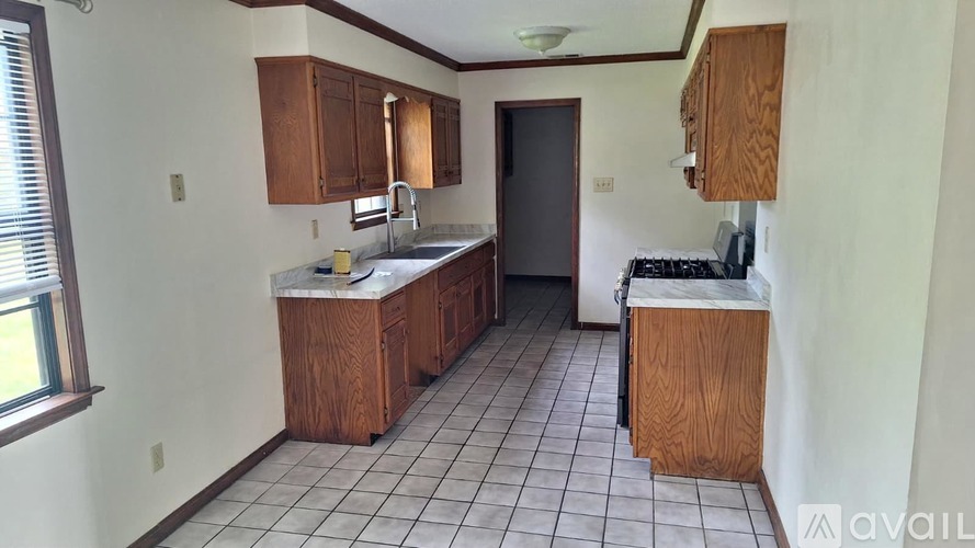 A kitchen with white tiles and wooden cabinets is available for rent.