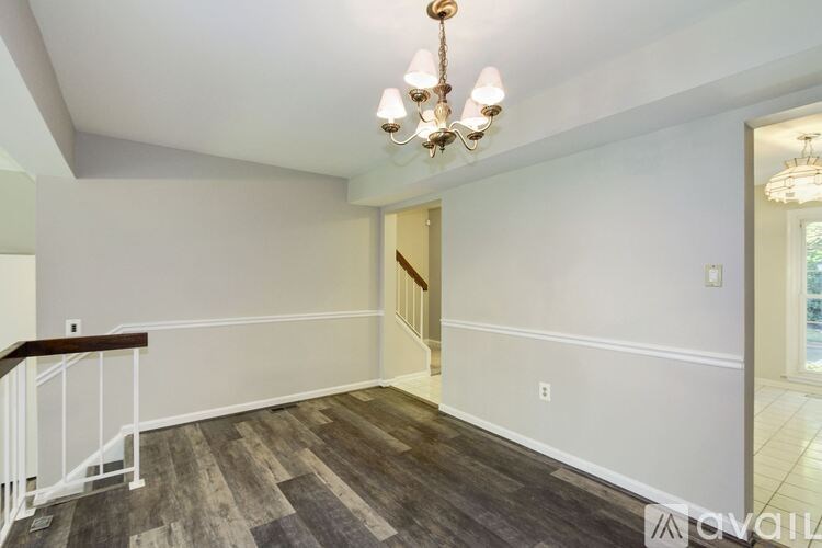 A room with a wooden floor and a chandelier hanging from the ceiling.