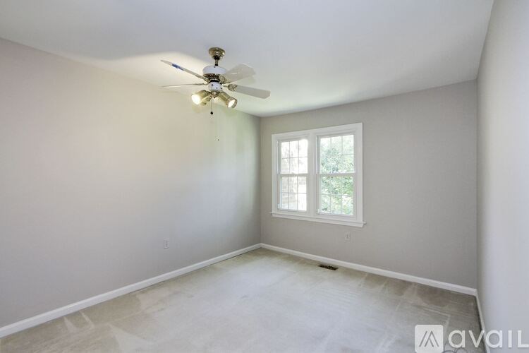 A room with a ceiling fan and a window.