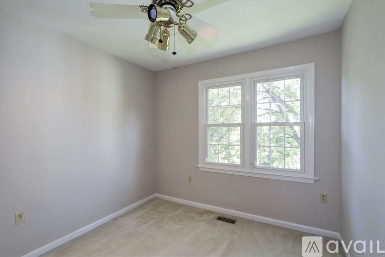 A room with a ceiling fan and a window.