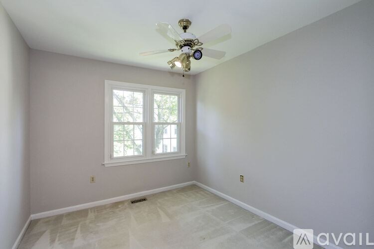 A room with a ceiling fan and a window.