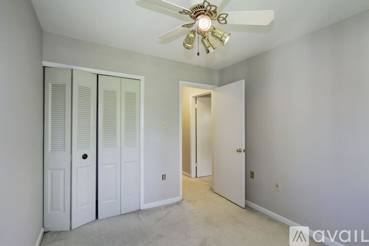 A room with a ceiling fan and three doors.