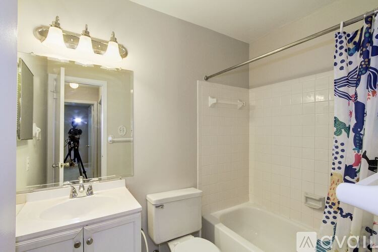 A bathroom with a white tub, sink, and toilet.