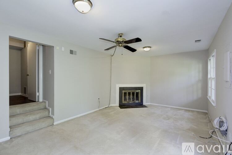 A room with a fireplace and a ceiling fan.