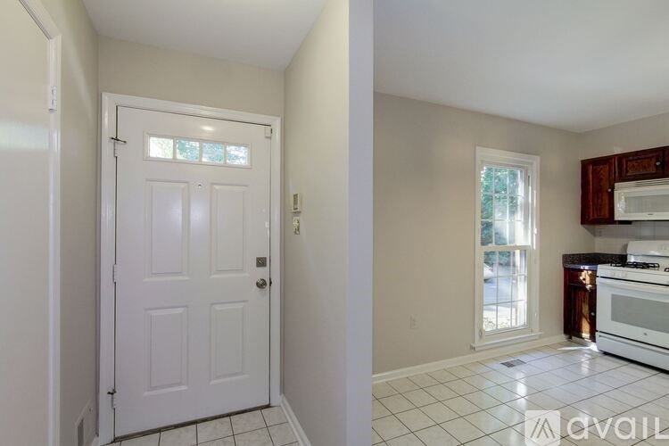 A white door is in a room with a tiled floor.