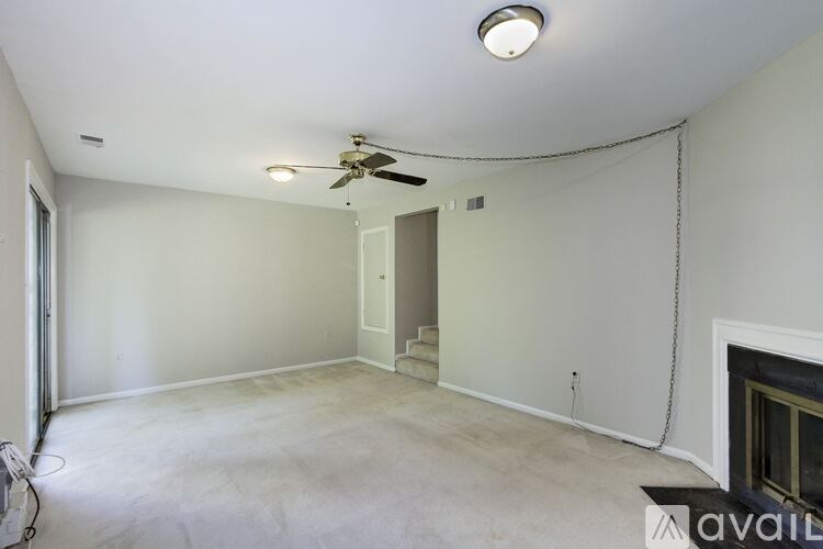 A spacious room with a ceiling fan and a fireplace.