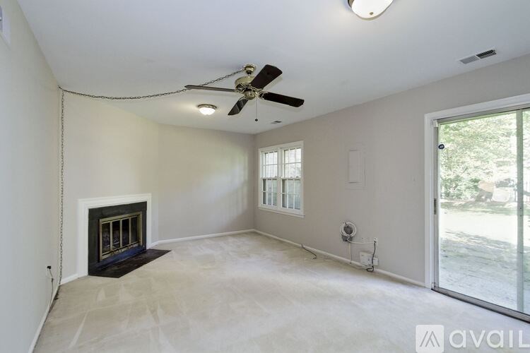 A spacious living room with a fireplace and sliding glass doors.