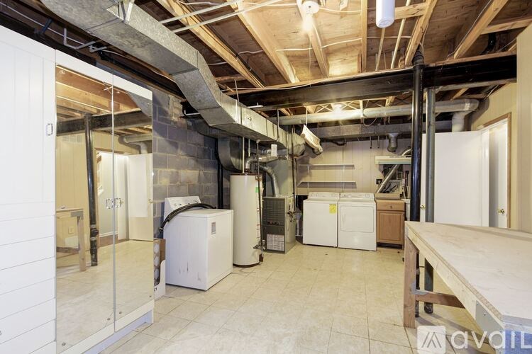 A room with a lot of white appliances and a wooden table.