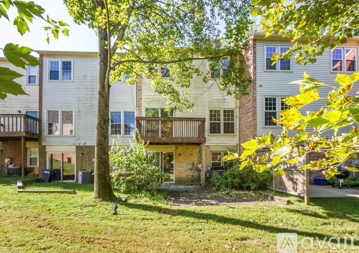 A tree with yellow leaves is in front of a building.