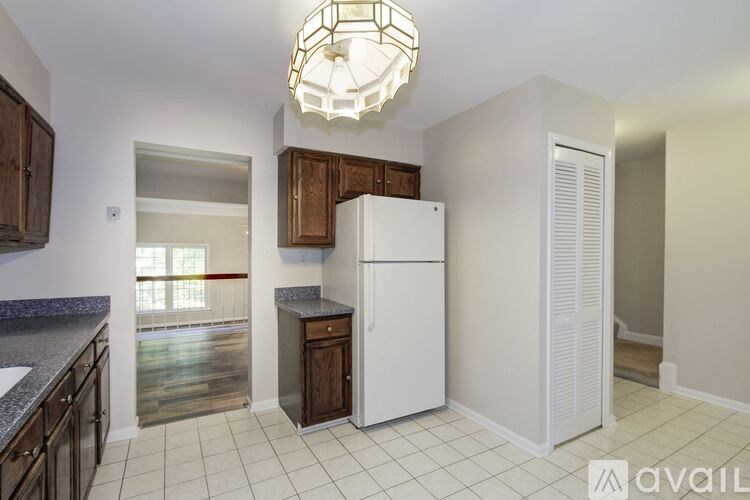 A kitchen with a white refrigerator and wooden cabinets.
