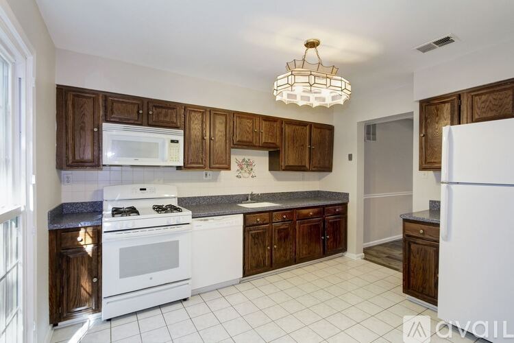 A kitchen with white appliances and brown cabinets.