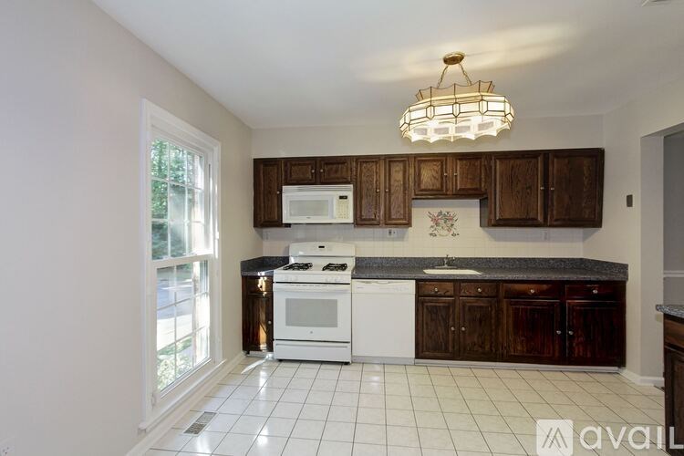 A kitchen with white appliances and brown cabinets.