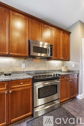 A kitchen with wooden cabinets and a granite countertop.