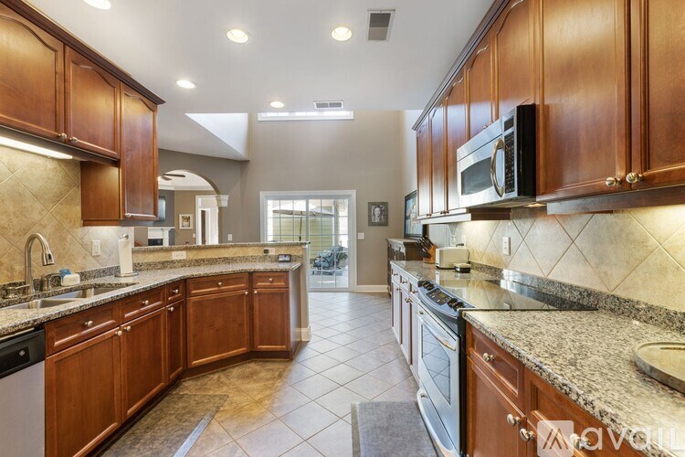 A kitchen with brown cabinets and a granite countertop.