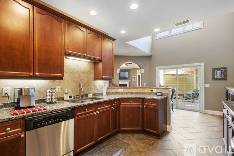 A kitchen with wooden cabinets and a stainless steel dishwasher.