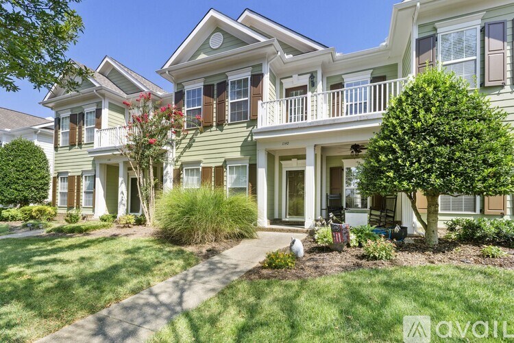 A house with a green lawn and a tree in front.