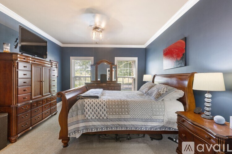 A bedroom with a bed, dresser, and mirror.