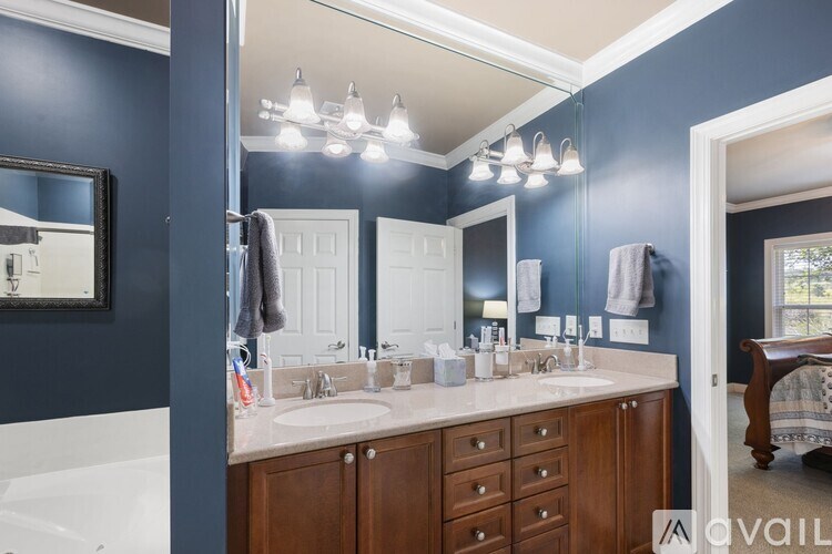 A bathroom with blue walls and a white tub.