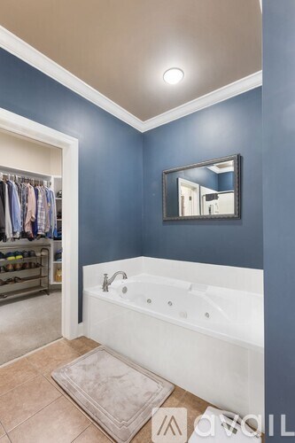 A bathroom with blue walls and a white bathtub.