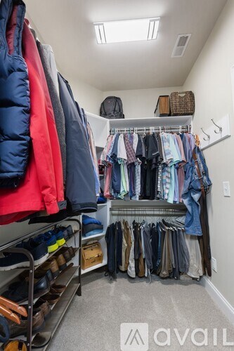 A well-organized walk-in closet with clothes and shoes neatly arranged on shelves and racks.