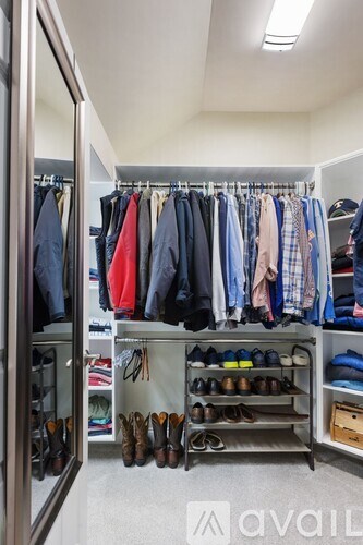 A well-organized walk-in closet with clothes and shoes neatly arranged.